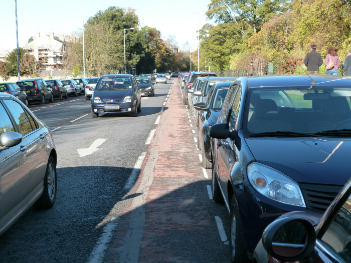 Cycle lane by parked cars Cycle lane by parked cars